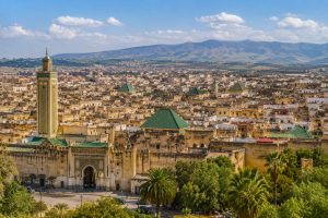Panoramic view of the UNESCO-listed Medina of Meknes featuring historic city walls, traditional rooftops, mosques, and the Imperial City skyline in Morocco.
