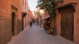 Authentic ochre-colored medina street in Taroudant, Morocco, with traditional wooden doors and local craft stalls